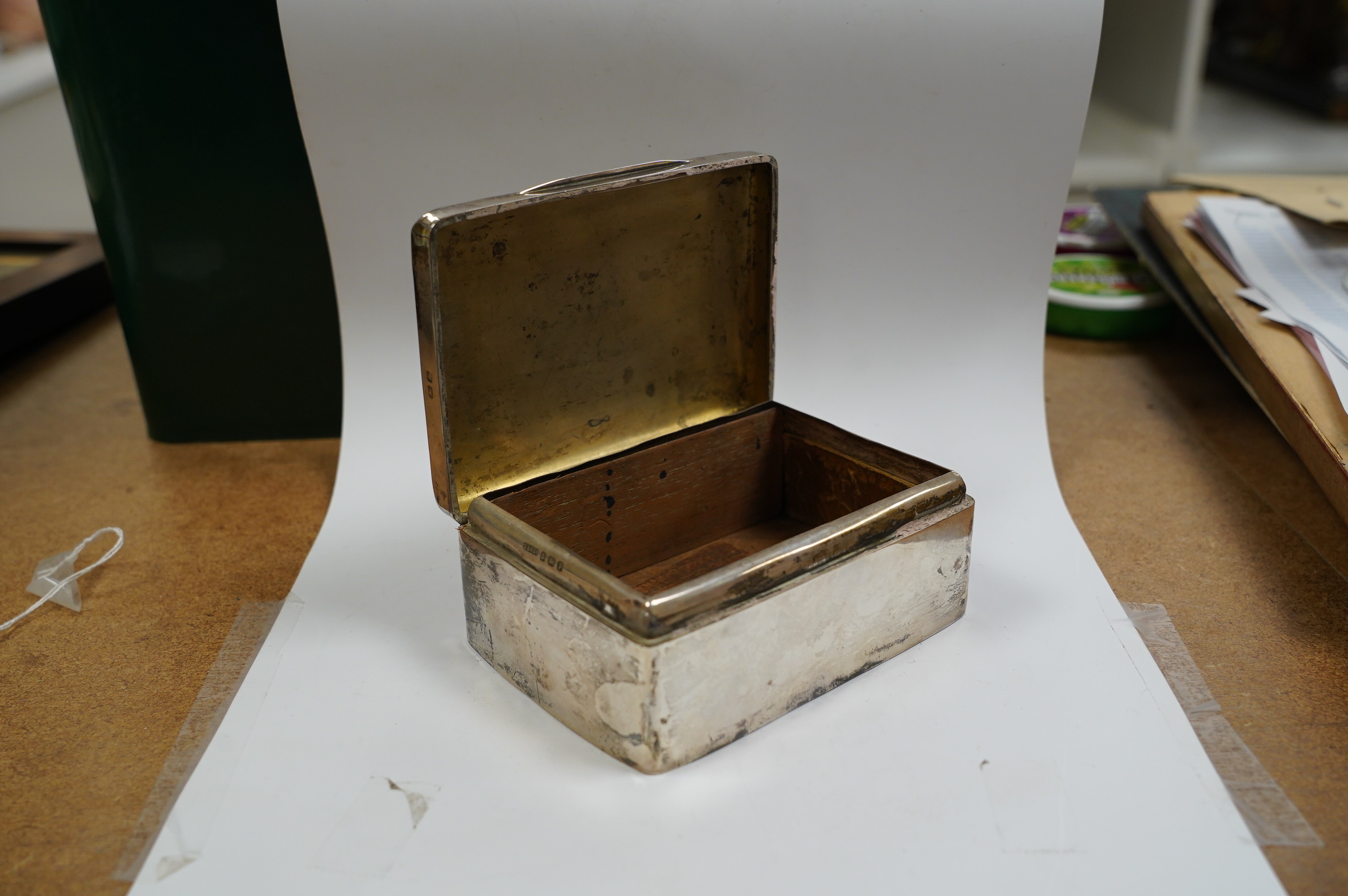 A George V silver mounted rectangular cigarette box, D. Bros, Birmingham, 1914, 12.4cm. Condition - poor